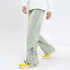 A person is dressed in Kanye Streetwear Store's washed blue ankle zipper jeans and a white long-sleeve shirt. They are also sporting bright yellow sneakers with purple accents, set against a plain, light-colored background.