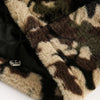 Image showcasing a detailed view of the Fuzzy Cheetah Camouflage Patchwork Fleece Jacket by Vexlly, highlighting its camouflage-patterned faux fur in hues of brown, green, and beige. The partially folded fabric reveals a black quilted lining and features a black drawstring with a silver toggle.