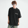 A person wearing a loose black Bloody Skeleton Graphic Tee by Vexlly, paired with jeans and dark sunglasses. They have layered necklaces and bracelets, exuding a Y2K streetwear vibe while standing against a plain white background.