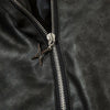 Close-up of the Vexlly Elemental Black Streetwear Coat showcasing a shiny silver zipper with a distinctive star-shaped pull. Its smooth, slightly wrinkled texture underscores its quality, making it ideal for those who appreciate men's fashion.