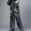 A person wearing Vexlly's 2024 Ropa Grunge Y2K Vintage Black Stacked Ripped Baggy Jeans, complete with a belt, stands on a sidewalk. The designer jeans feature multiple frayed holes that reveal skin beneath. The setting is urban, with a concrete wall and pavement in the background.