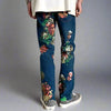 A person is wearing Floral Print Slim Jeans in Blue from Kanye Streetwear Store, standing against a plain background. They have paired the slim-fit jeans with a white shirt and beige sneakers.