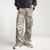 A person wearing Cargo Pants Y2K Fashion Side Pockets Camouflage Baggy Cargo Jeans from Kanye Streetwear Store and white sneakers stands against a plain background. They are also wearing a dark jacket with their hands in the pants' pockets, exuding a casual yet trendy look.