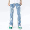 A person wearing the Y2K Patchwork Baggy Flare Jeans in Blue from Kanye Streetwear Store and trendy green-and-white sneakers stands confidently against a minimalistic backdrop.